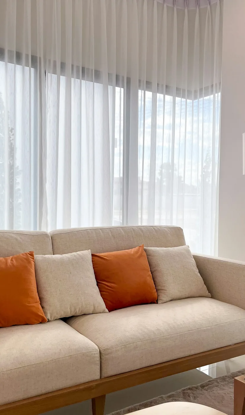 Floor-length curtains hanging from a slim track fixed to the ceiling