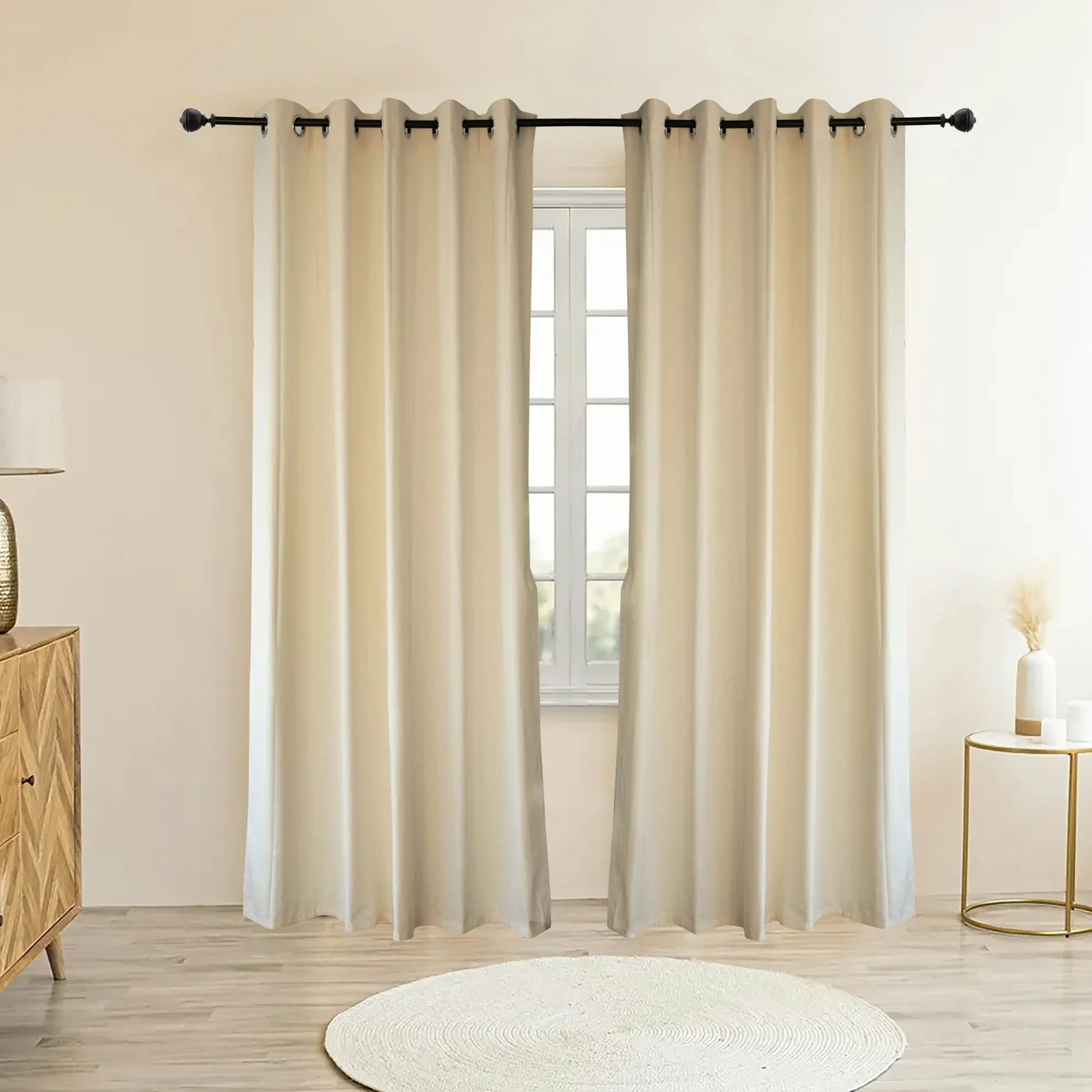 Eyelet curtains hanging in deep, even folds from a metal pole beside a window