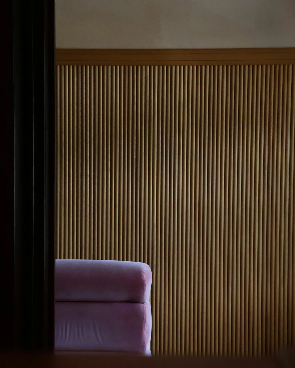 Vertical fluted wall panels with soft light grazing the ribs