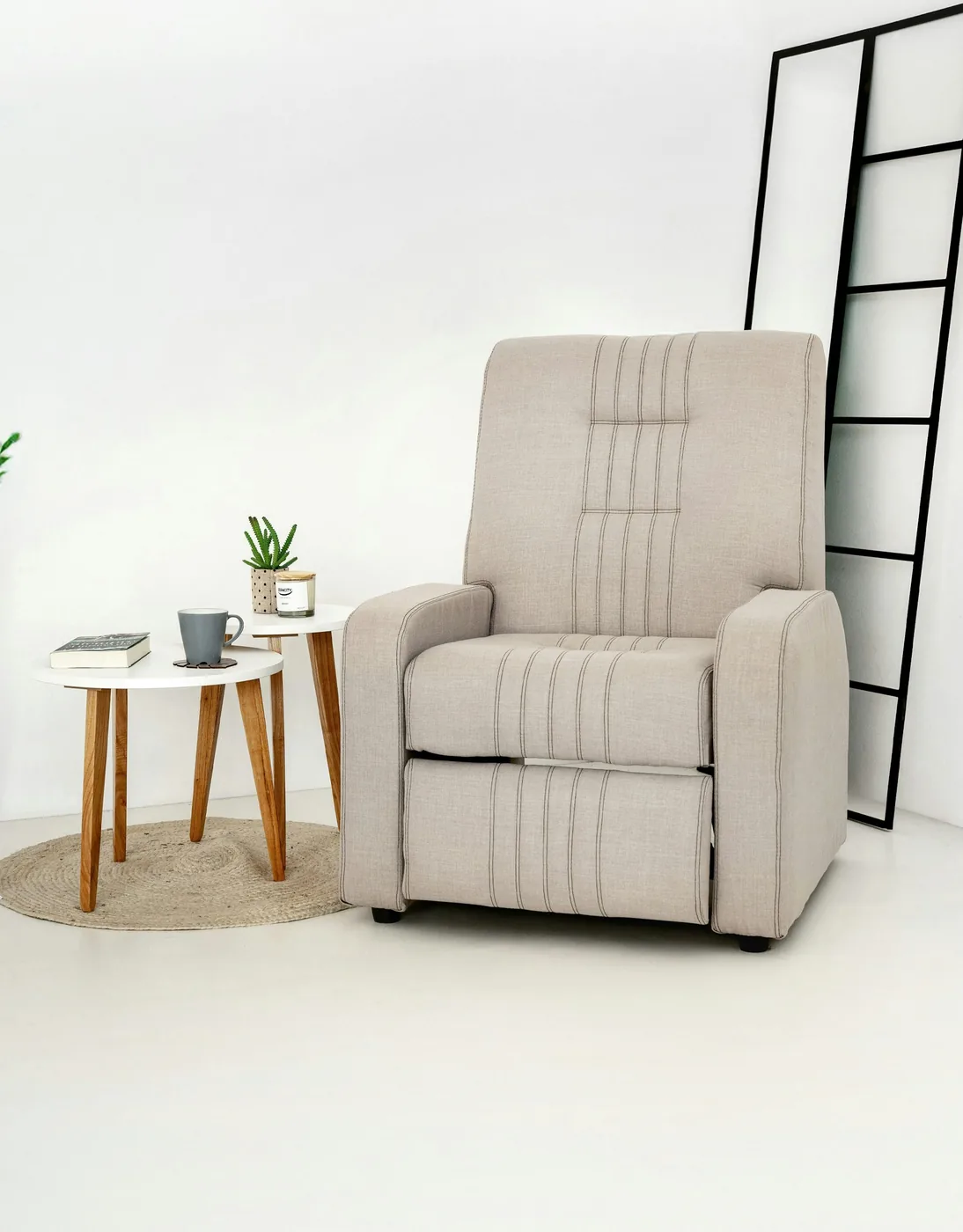 A recliner sofa with one seat tipped back and its footrest raised in a living room