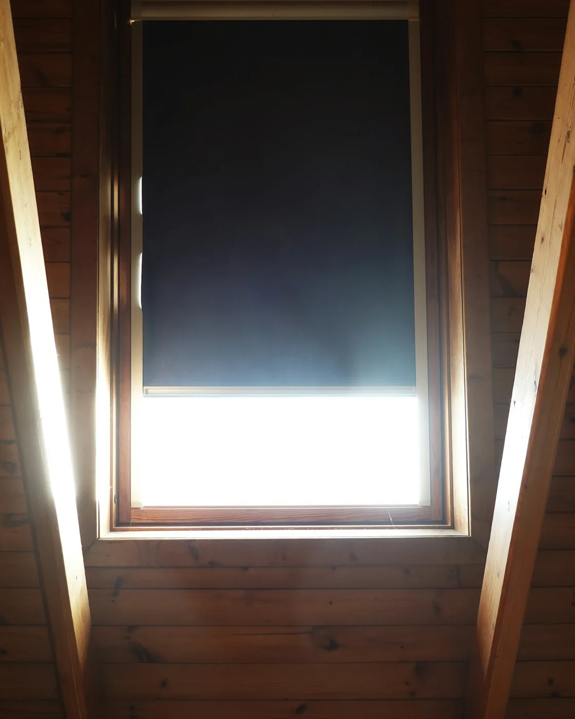 A tensioned fabric blind drawn across overhead skylight glazing
