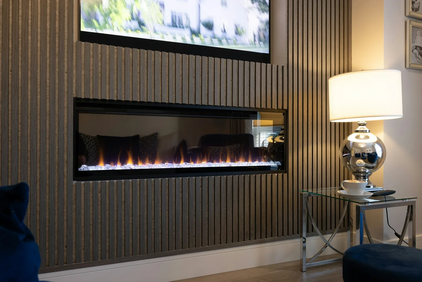 A panelled TV wall with a wall-mounted screen and a low floating unit