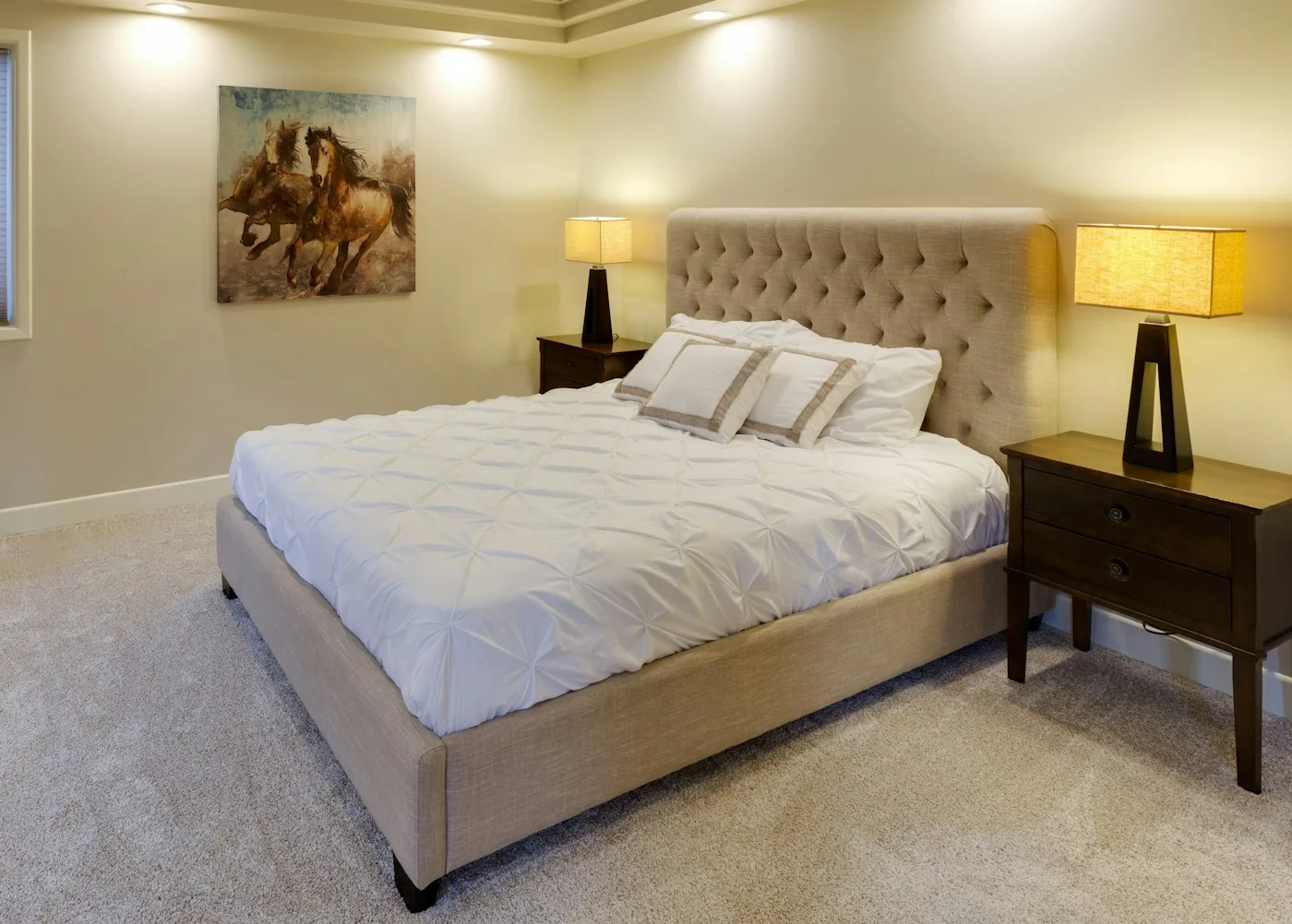 A bedroom with soft wall-to-wall carpet and an upholstered bed
