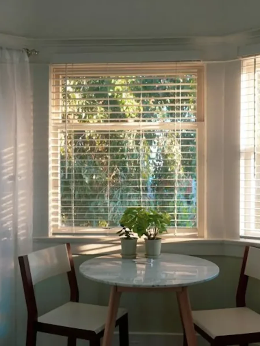 Arched window in a Goan house with a curtain hung on a straight pole above the arch