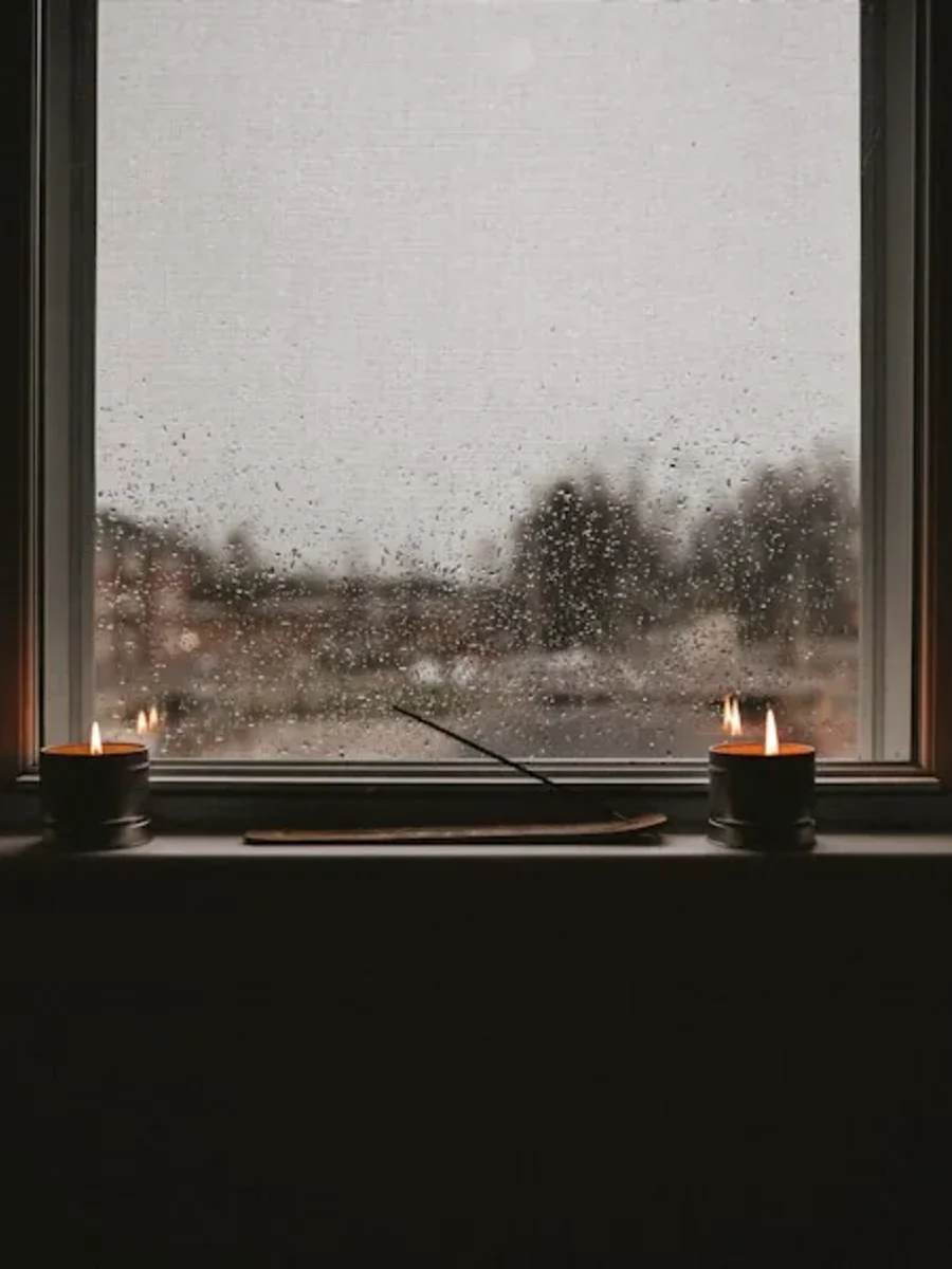 Heavy monsoon rain against a window of a Goan home