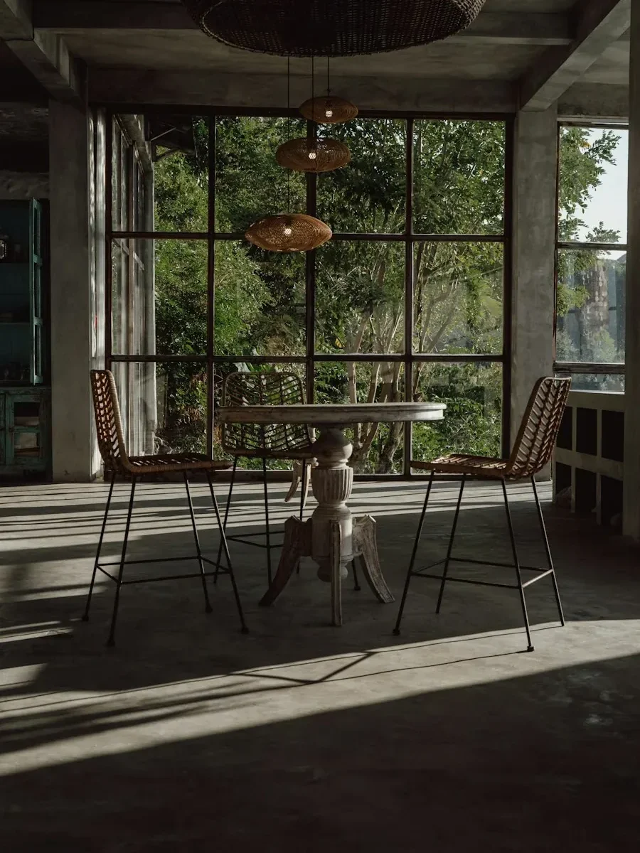 A shaded outdoor terrace with a table and chairs