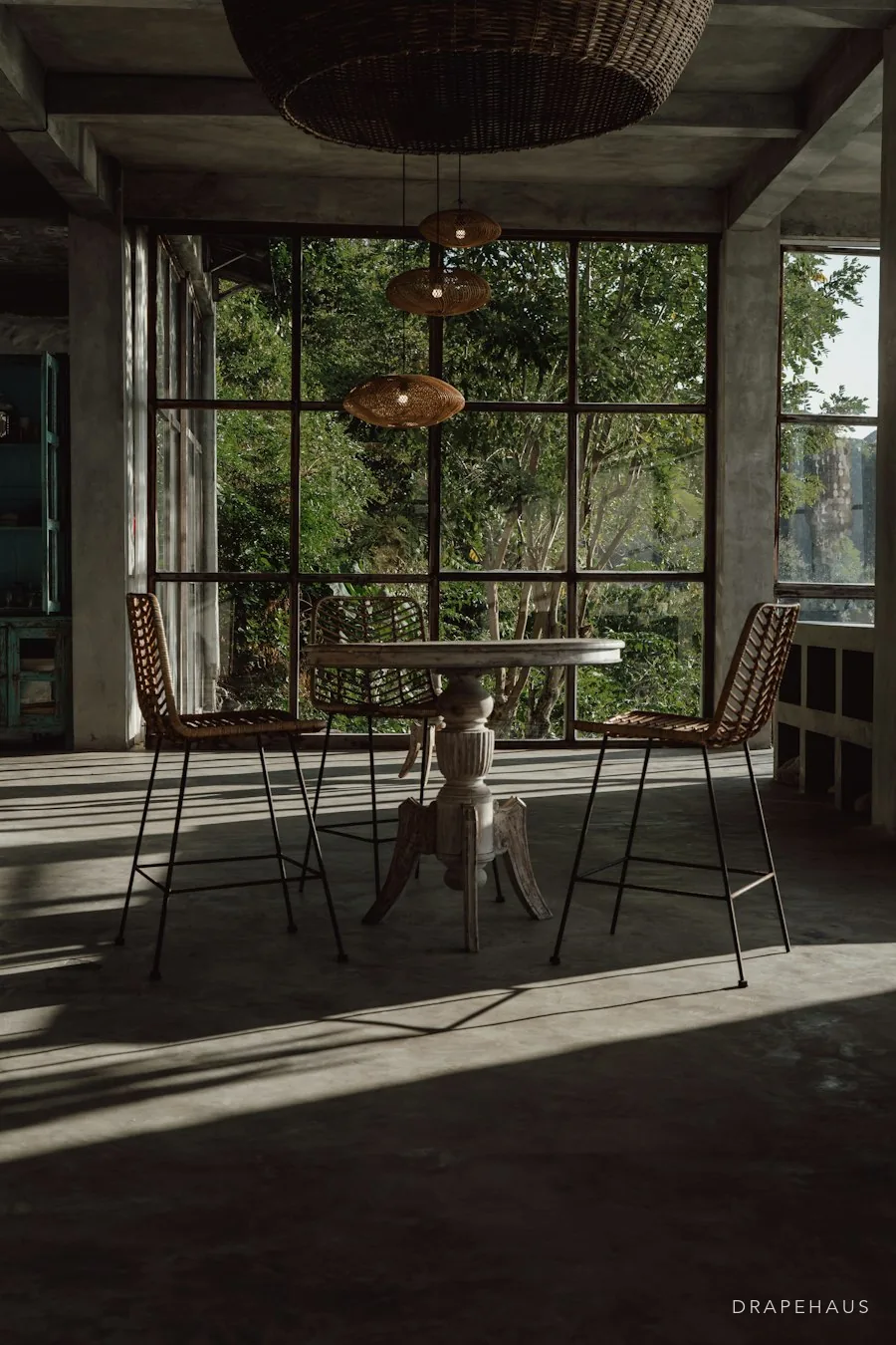 A shaded outdoor terrace with a table and chairs