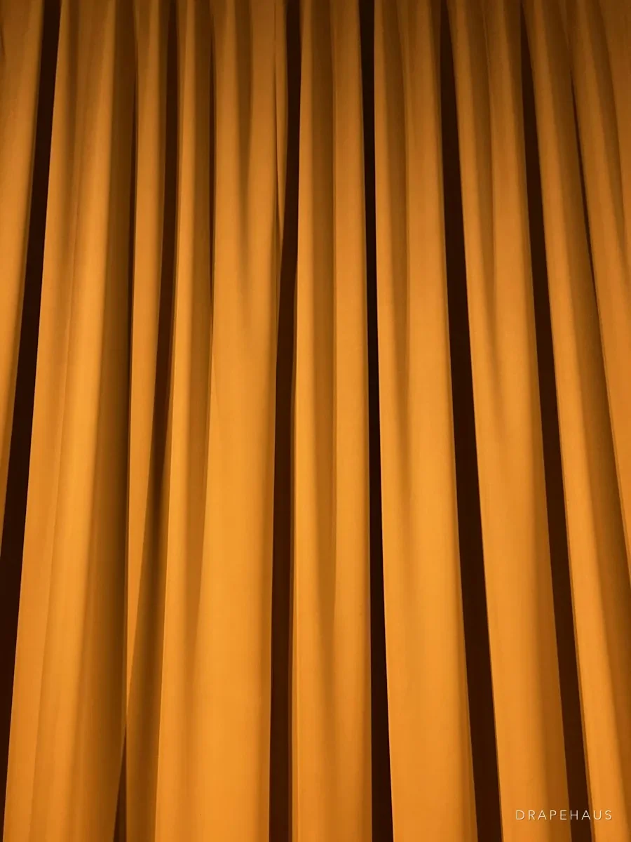 Deep amber velvet curtains falling in heavy folds