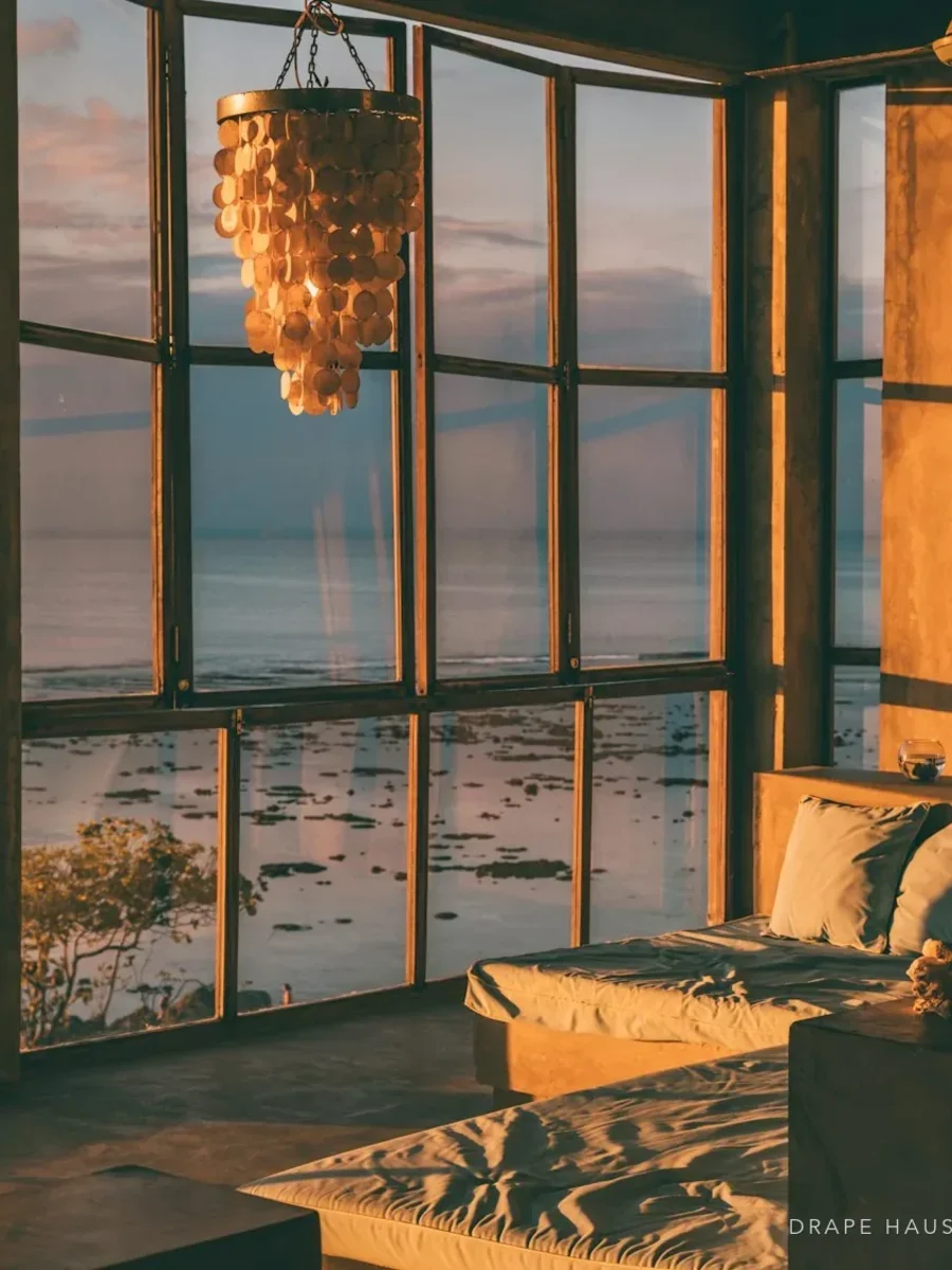 Riverside house in Goa with windows looking out over a tidal river at dusk