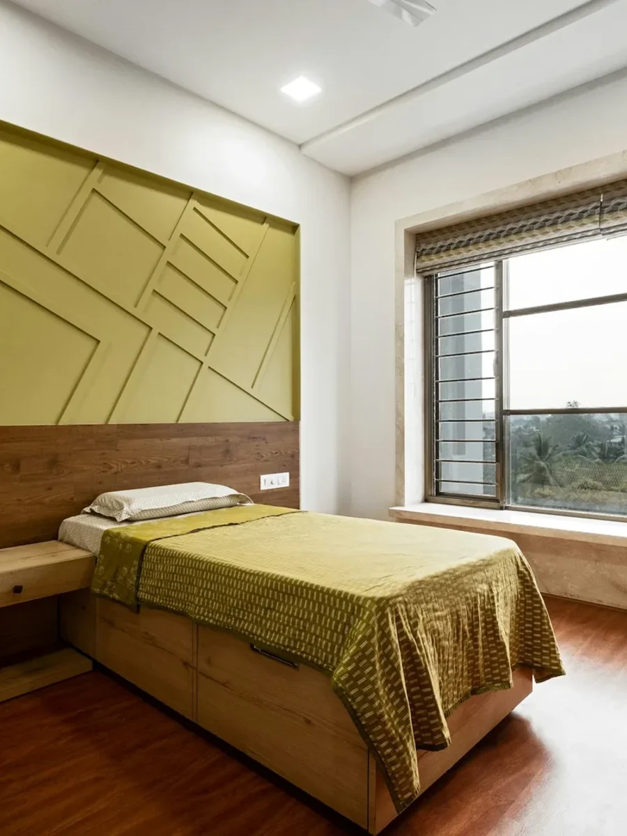 Bedroom headboard wall with olive geometric panelling above a wood-laminate wainscot