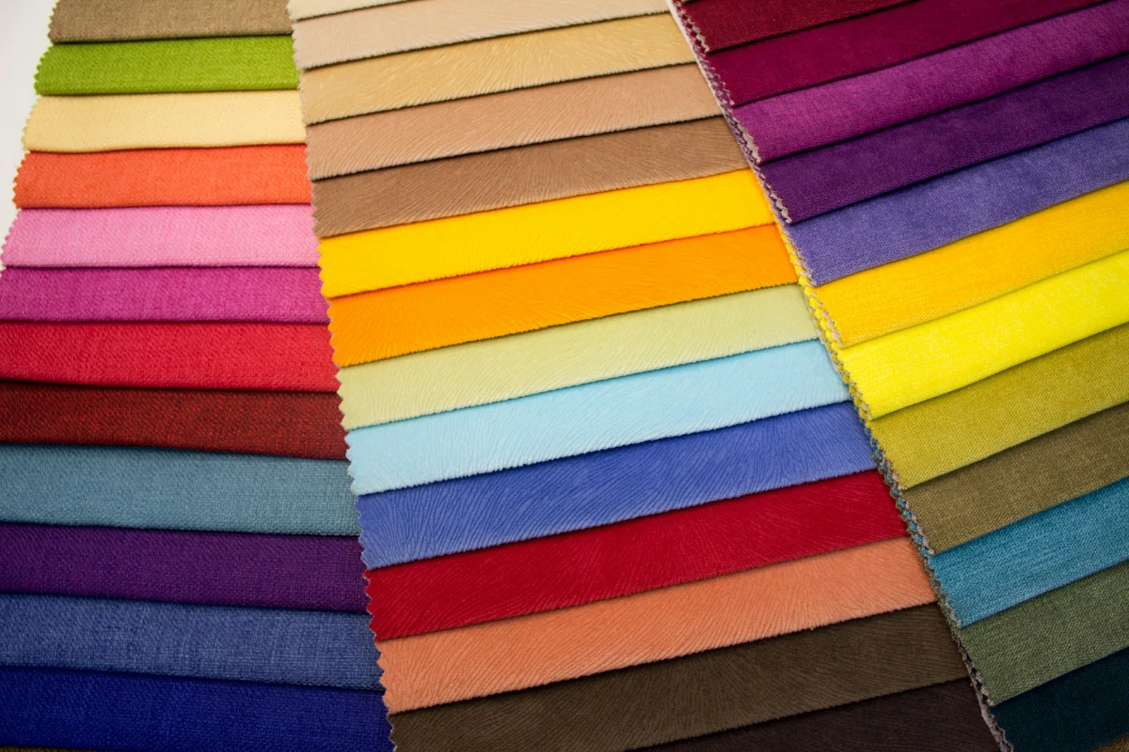 Fanned rows of upholstery fabric swatches in many colours and textures