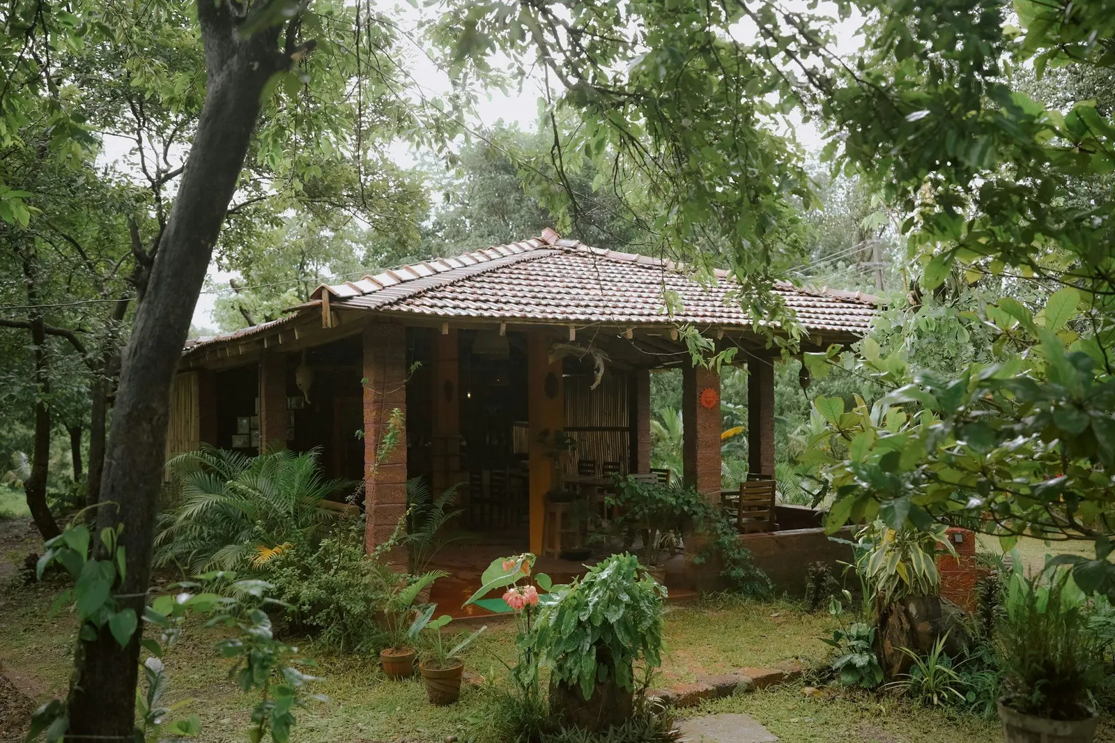 Traditional tiled-roof house with a laterite verandah set in a leafy garden in Valpoi, Goa