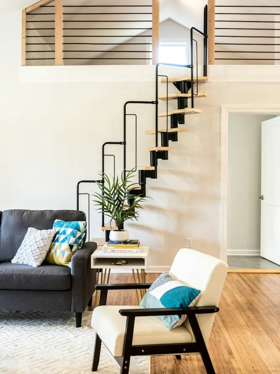 Double-height living room with a spiral stair rising to a loft gallery above the sofa