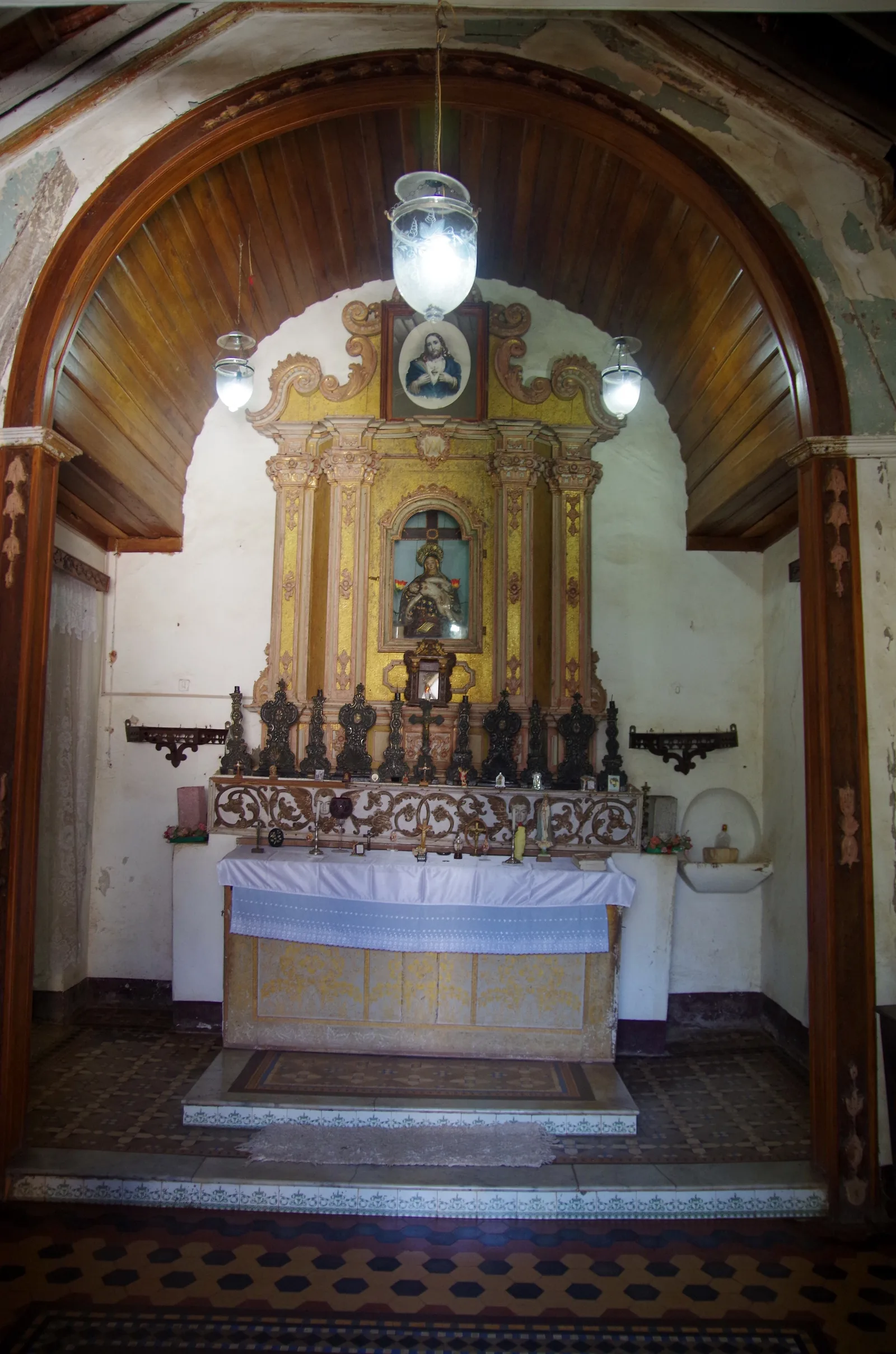 The gilded family altar in the private chapel of the Menezes Braganza house, under a timber barrel ceiling