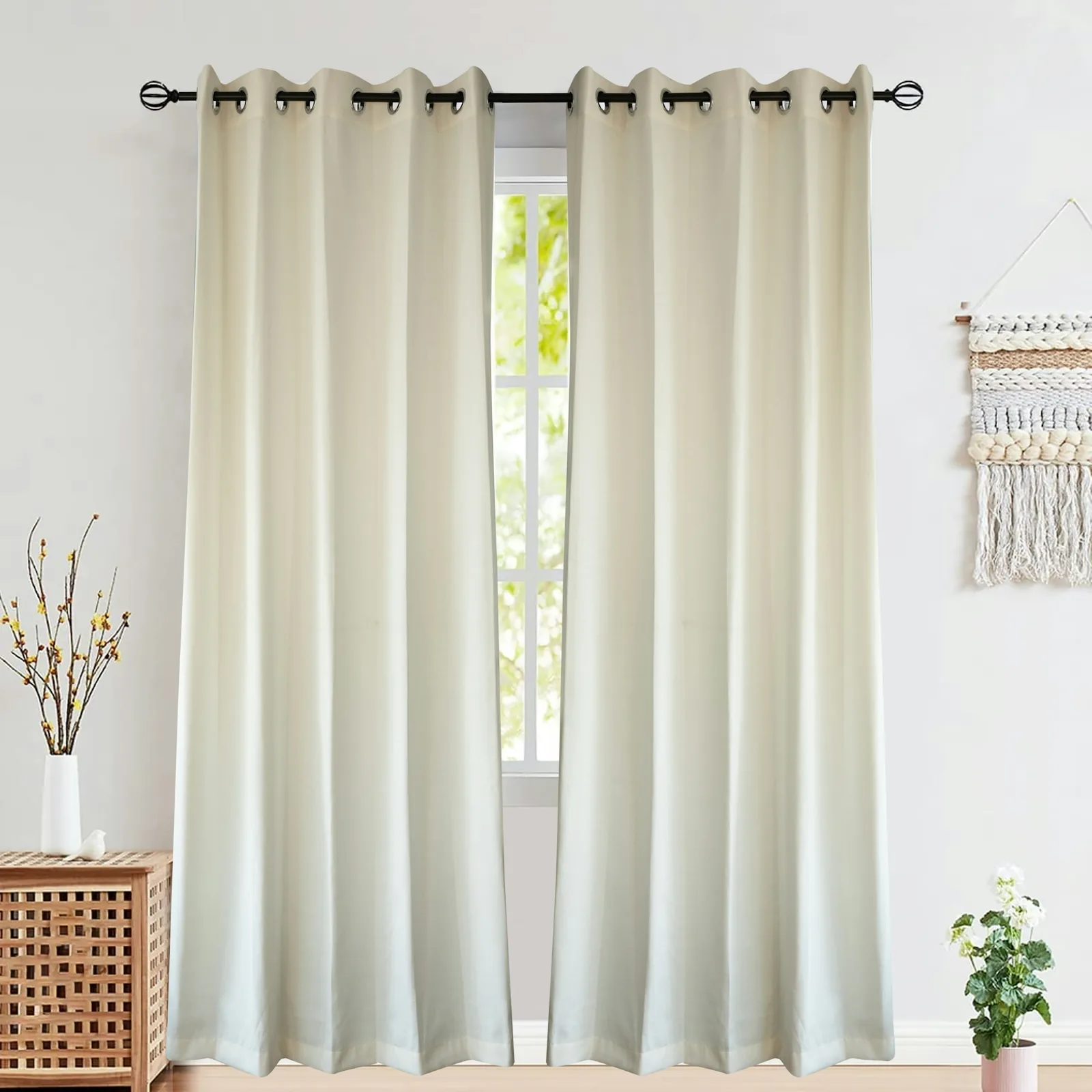 Cream eyelet curtains hung from a black rod over a window, with a side table and plant