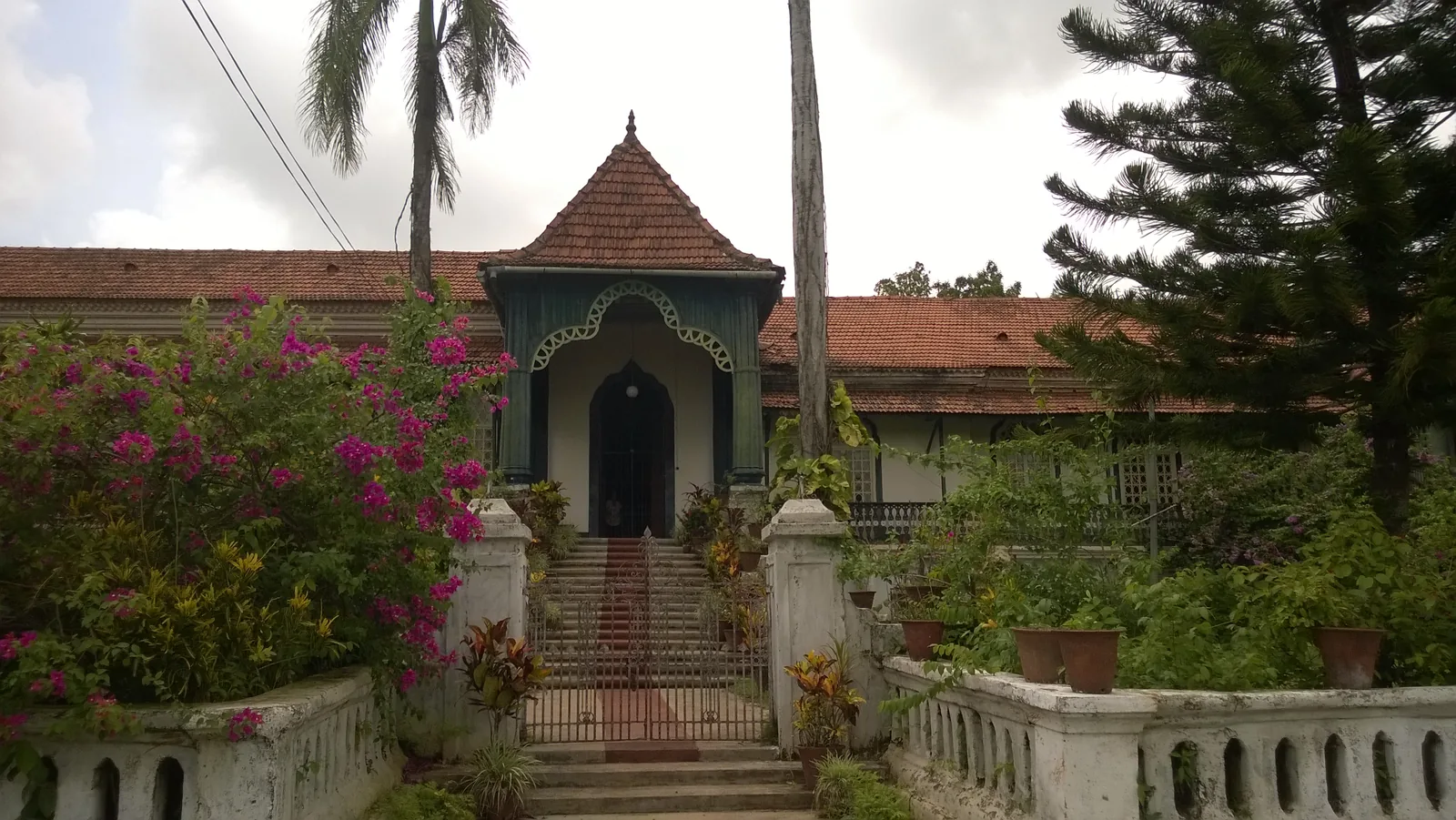 The Figueiredo mansion in Loutolim, a tiled-roof Goan house with porch, stone steps and bougainvillea