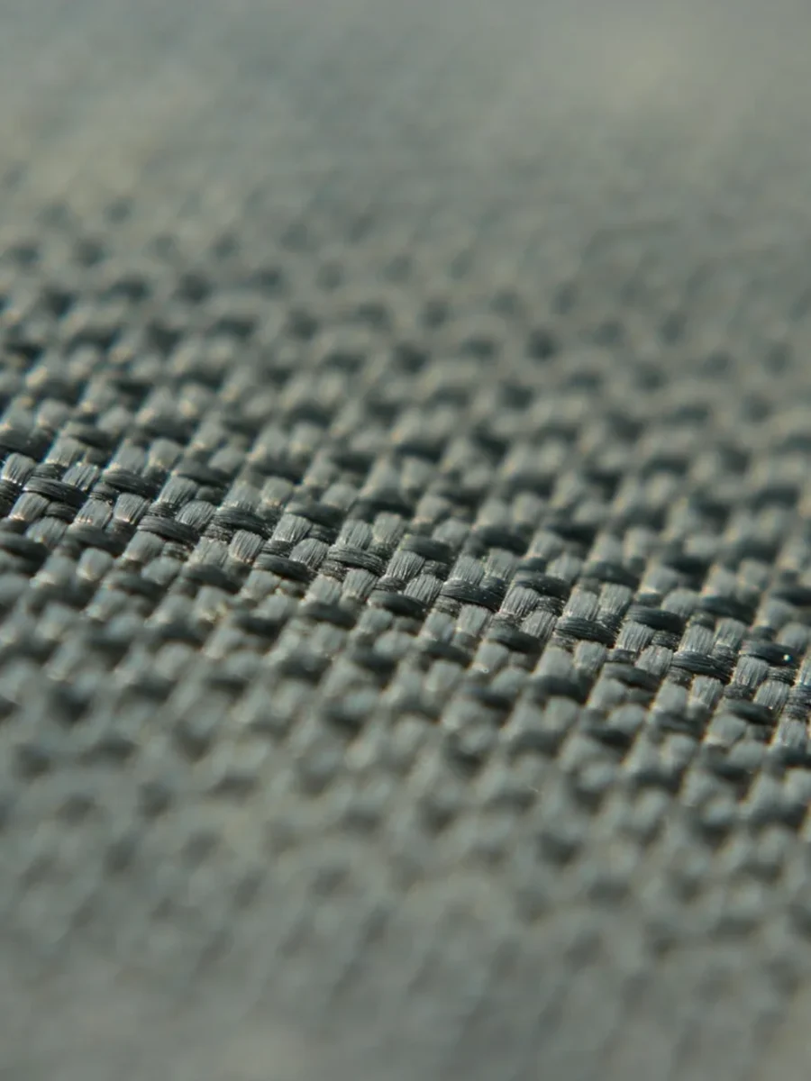 Close-up of a tightly woven grey-blue upholstery fabric showing its basket-weave texture