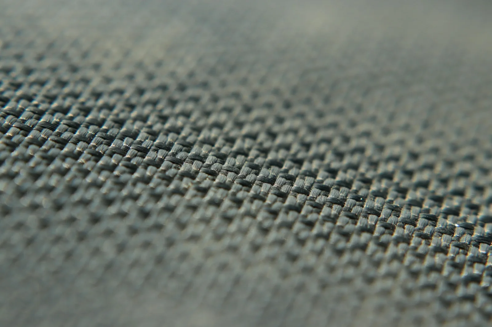 Close-up of a tightly woven grey-blue upholstery fabric showing its basket-weave texture