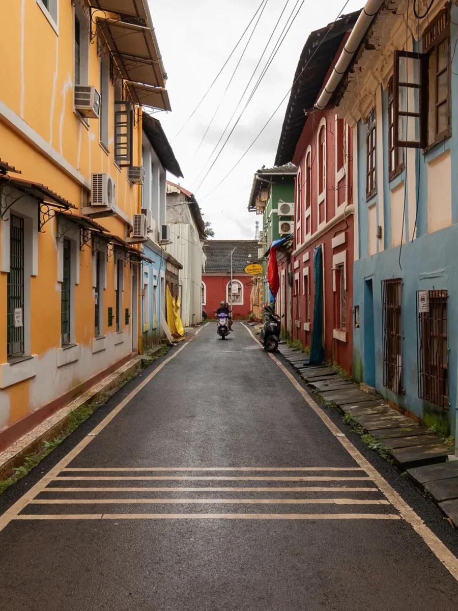 A narrow Fontainhas lane in Panjim lined with ochre, blue and red old houses after rain