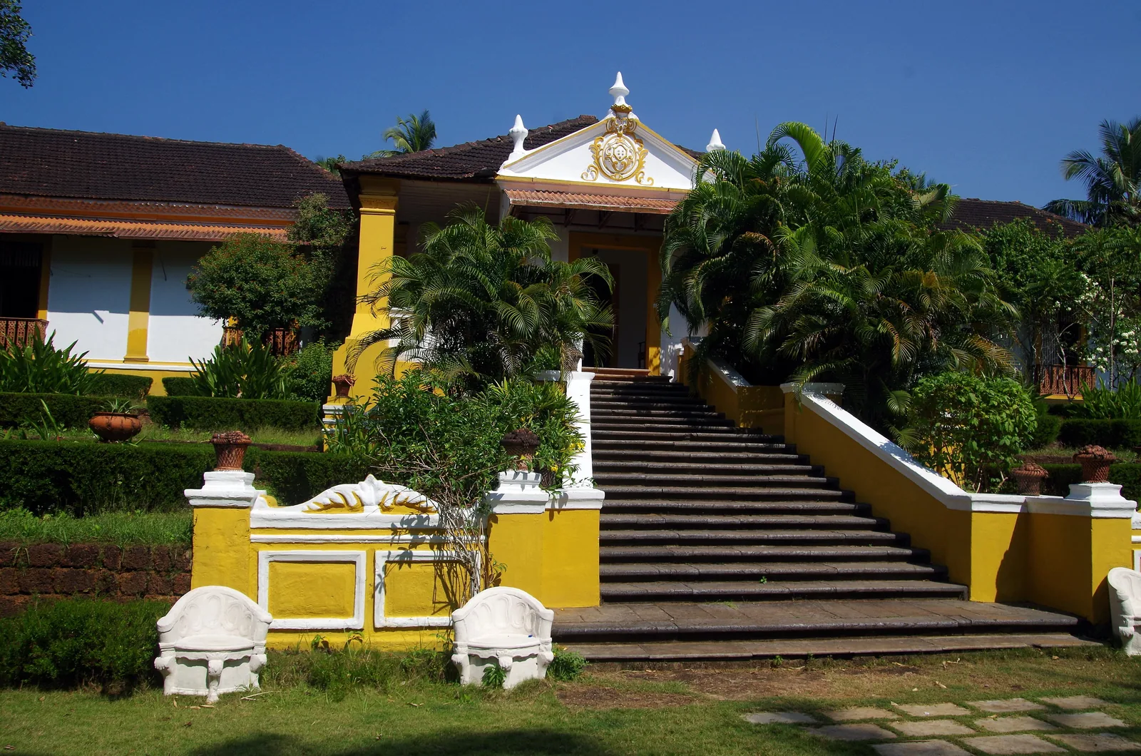 The yellow-and-white Palácio do Deão in Quepem, a Portuguese-era Goan house approached by a broad stone stair