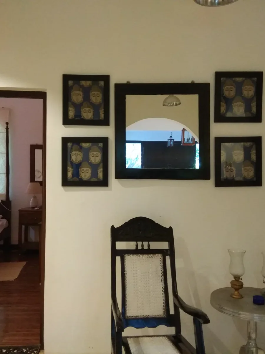 Inside a Goan house: a hall with a cane planter's chair and a doorway opening onto a four-poster bedroom
