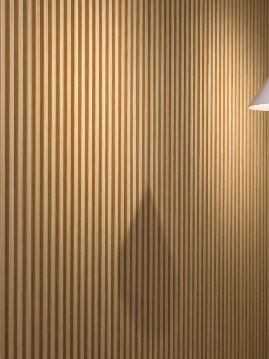 Light oak-effect slatted wall panels with a white cone pendant light hanging alongside