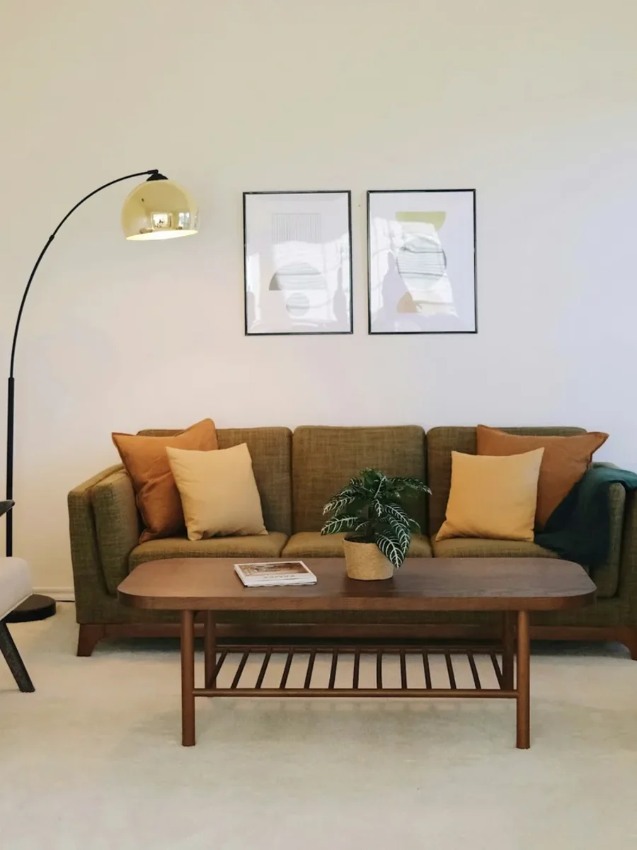 Olive three-seater sofa flanked by two wooden-framed armchairs around a walnut coffee table