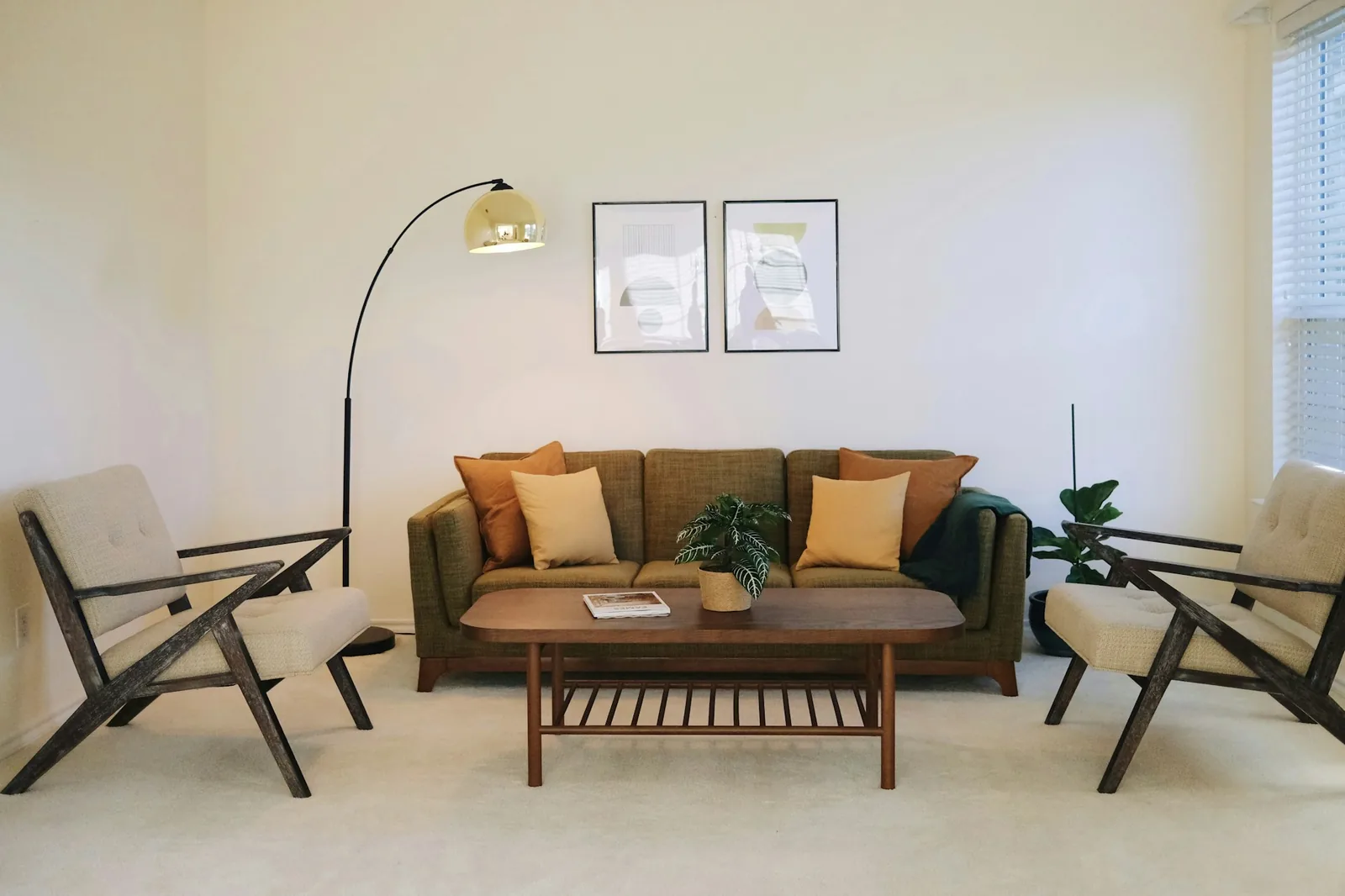 Olive three-seater sofa flanked by two wooden-framed armchairs around a walnut coffee table
