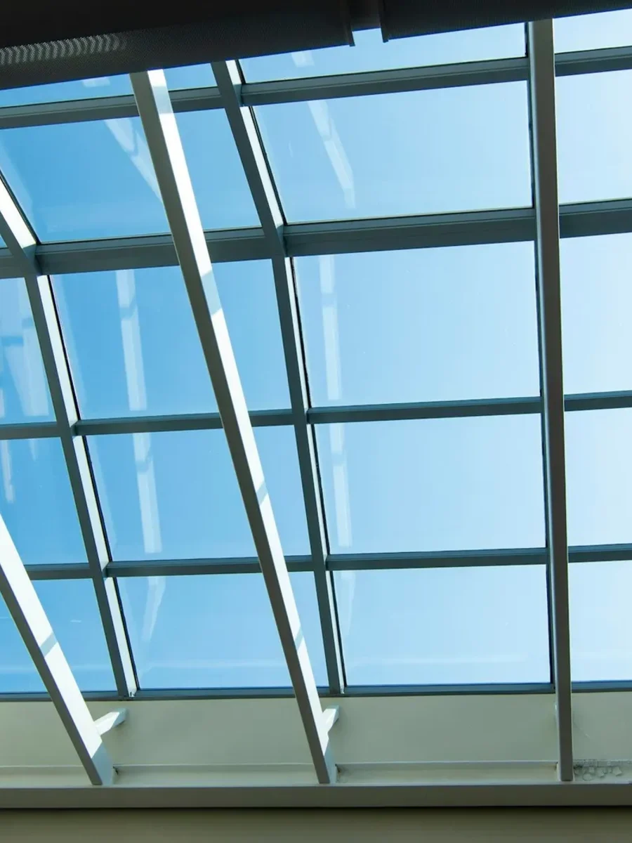 Large glazed skylight with white frames looking up at a clear blue sky