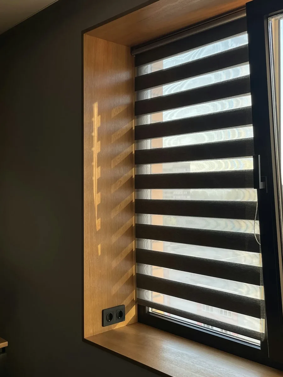 A day-and-night zebra blind with alternating sheer and solid bands in a timber-lined window