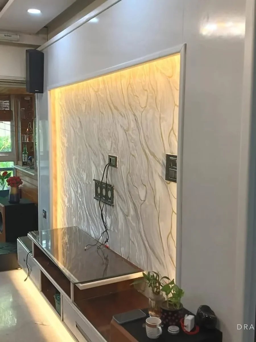 A backlit textured feature wall behind a low media unit