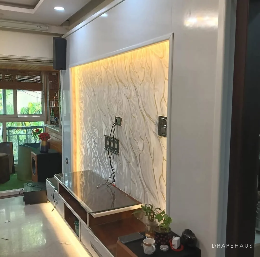 A backlit textured feature wall behind a low media unit