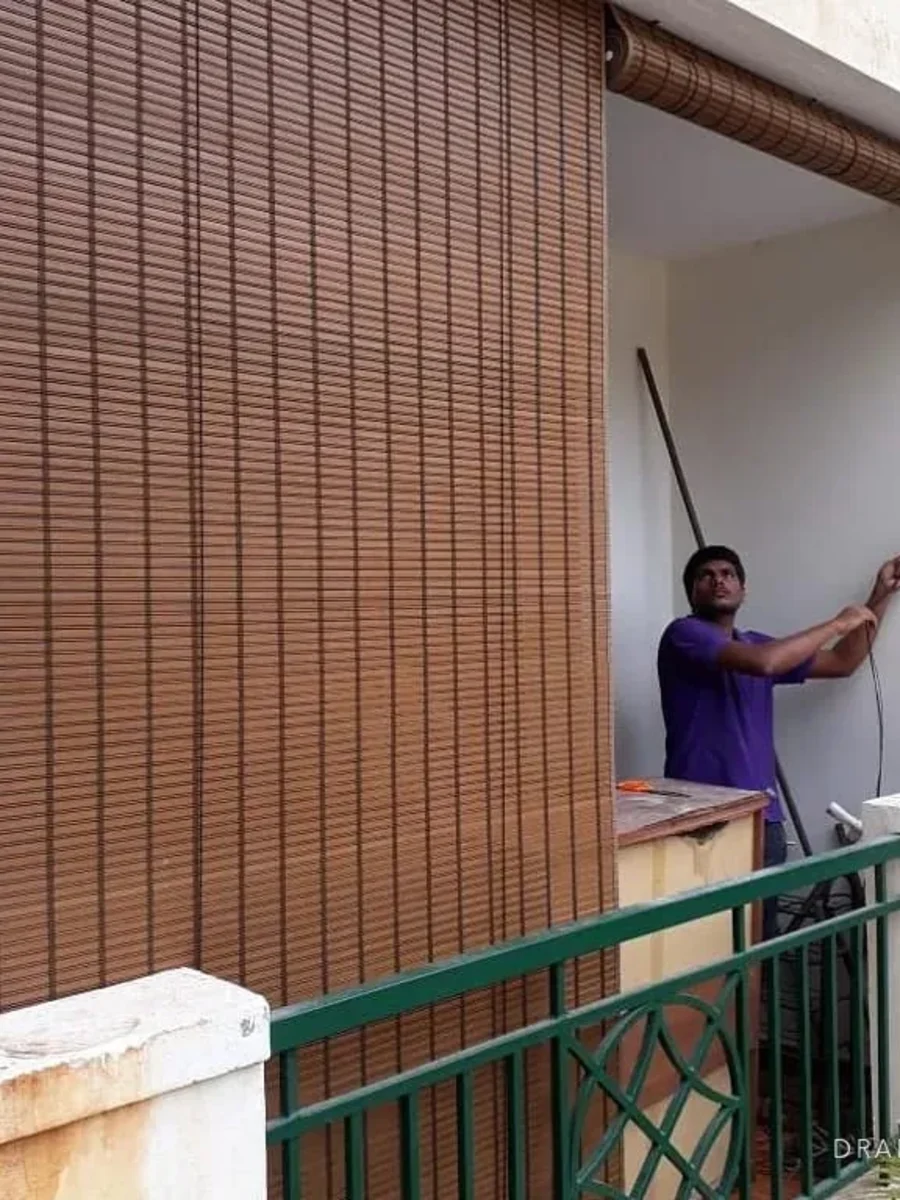 Bamboo chik blinds being fitted across a first-floor veranda