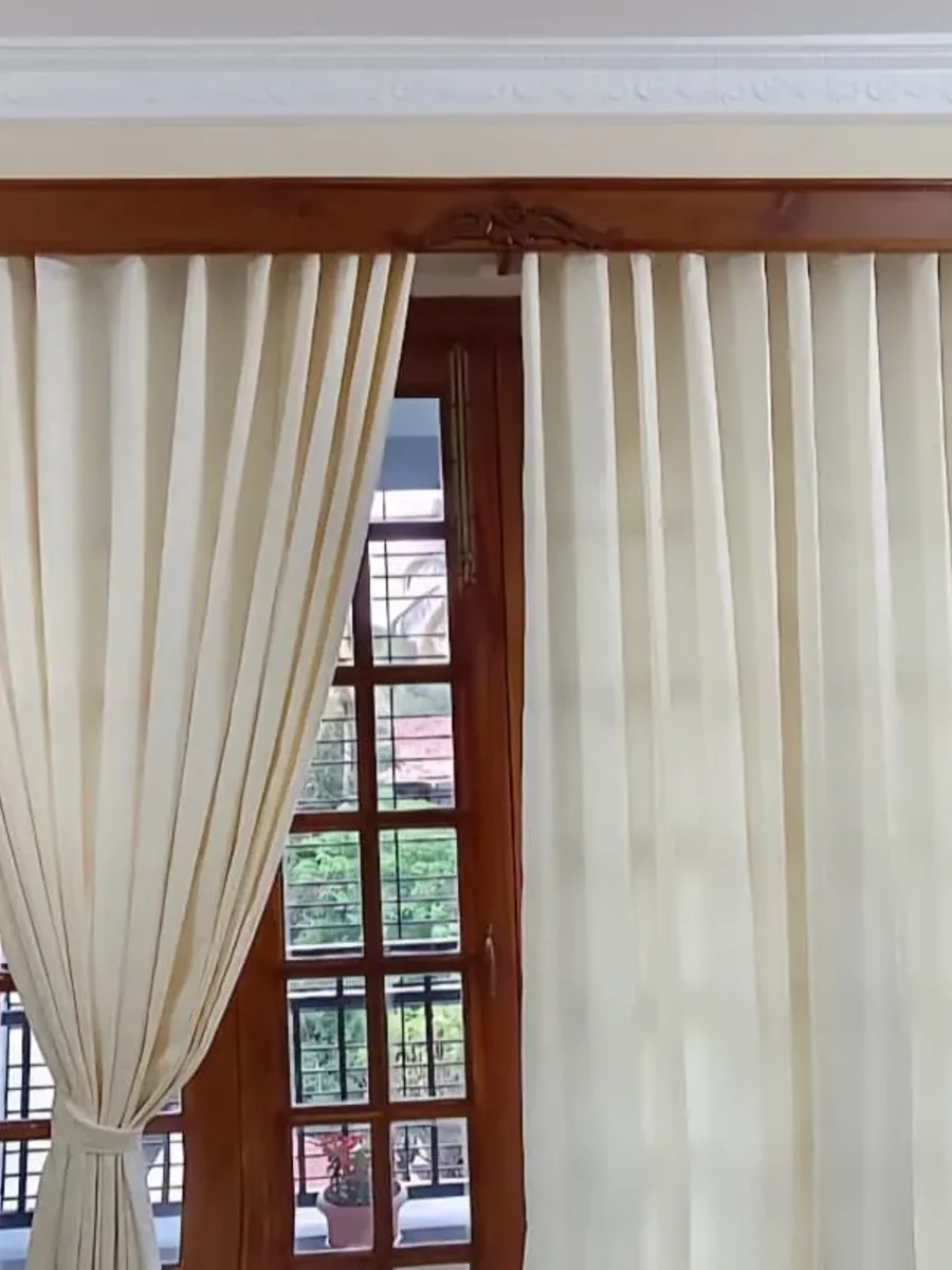 Ivory sheers tied back from timber French doors beneath a carved hardwood pelmet