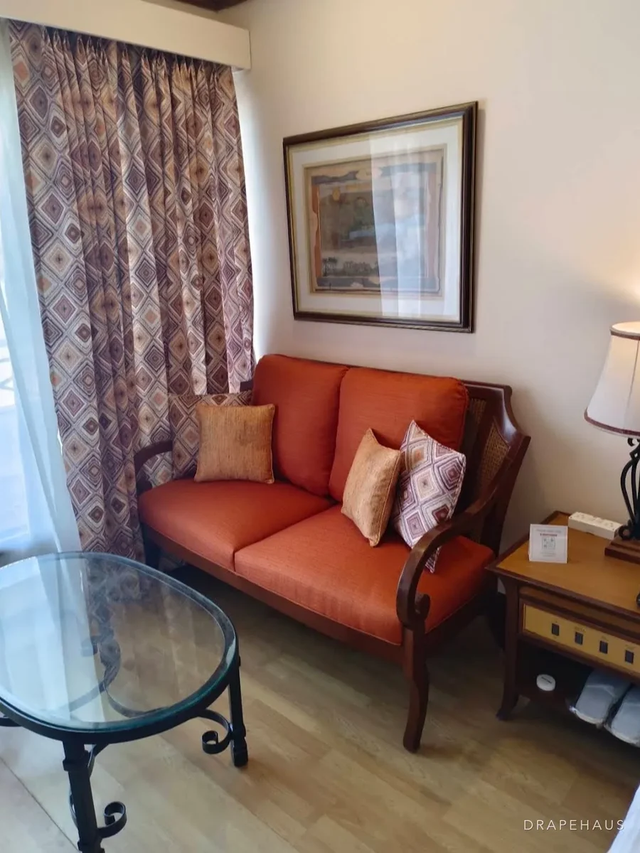 An orange upholstered sofa with patterned cushions in a resort lounge