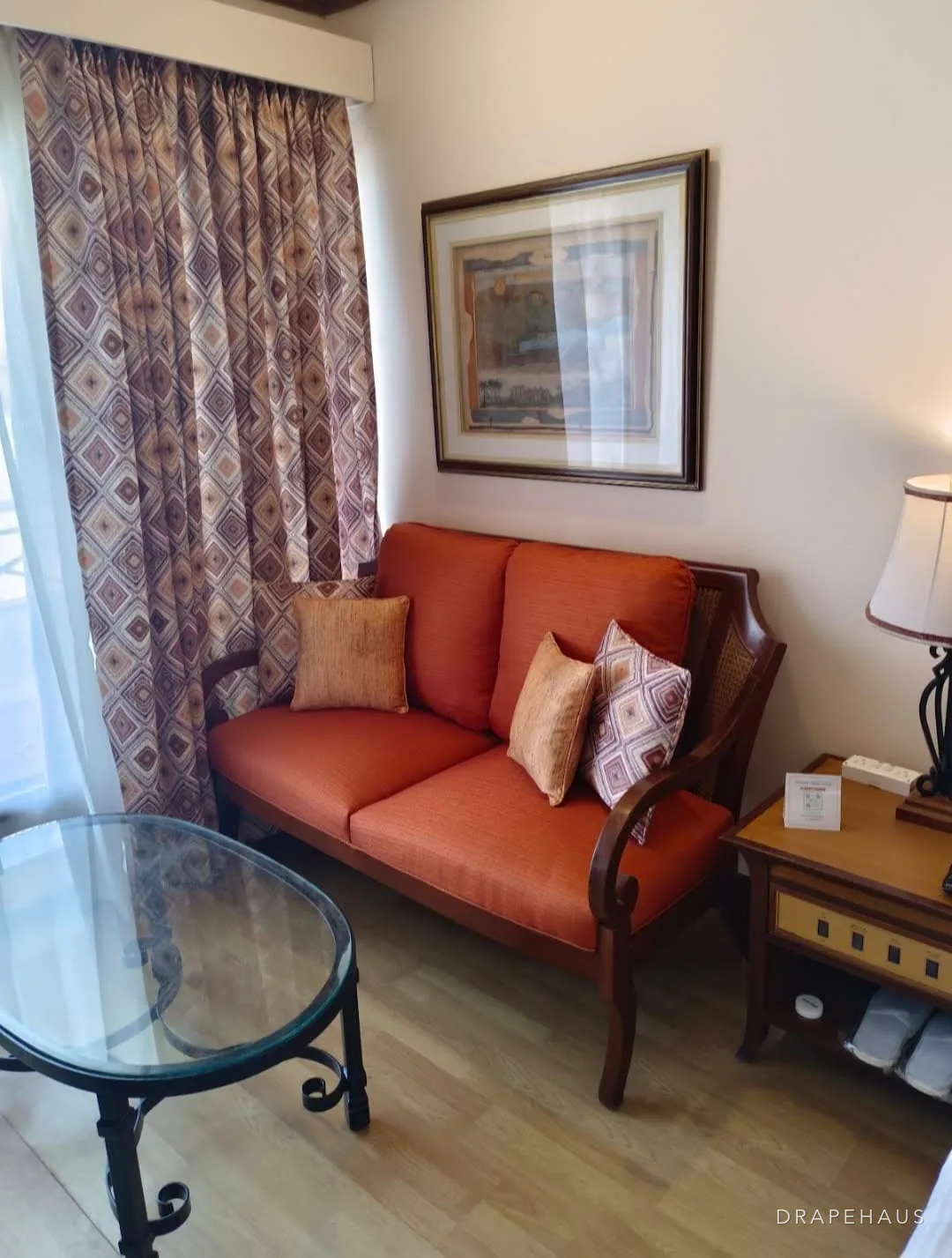 An orange upholstered sofa with patterned cushions in a resort lounge