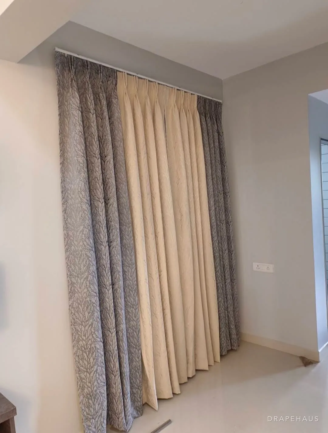 Floor-to-ceiling layered curtains on a ceiling track