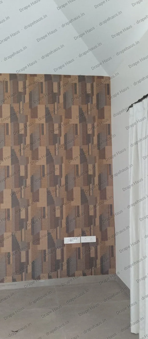 The papered feature wall seen from the side, with the sloping ceiling above and the sheer curtain beside it