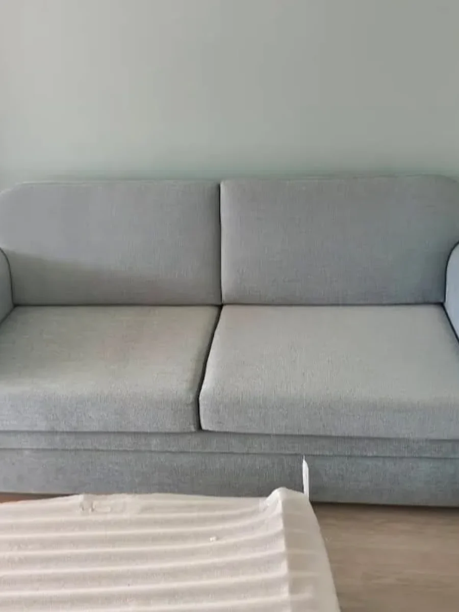 A sofa rebuilt and recovered in sage fabric with contrast piping