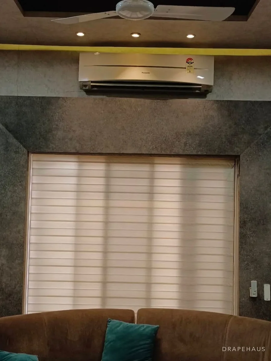 Living room of a Goan apartment with sliding balcony doors and sheer curtains