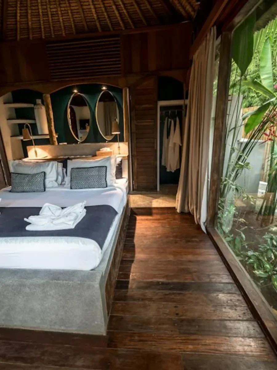A guest bedroom made up for the season, opening onto a shaded veranda