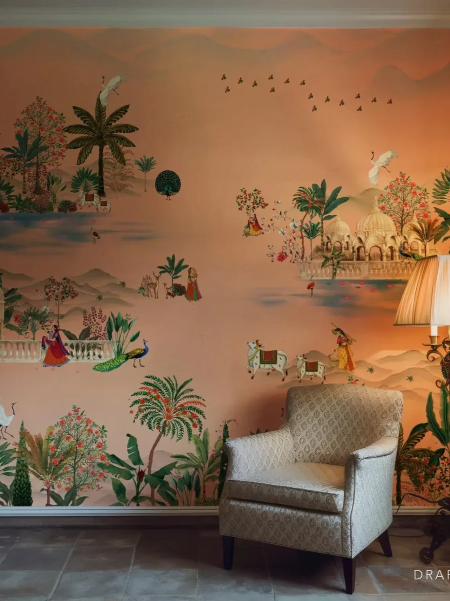 A botanical mural wallpaper behind an armchair in a living room