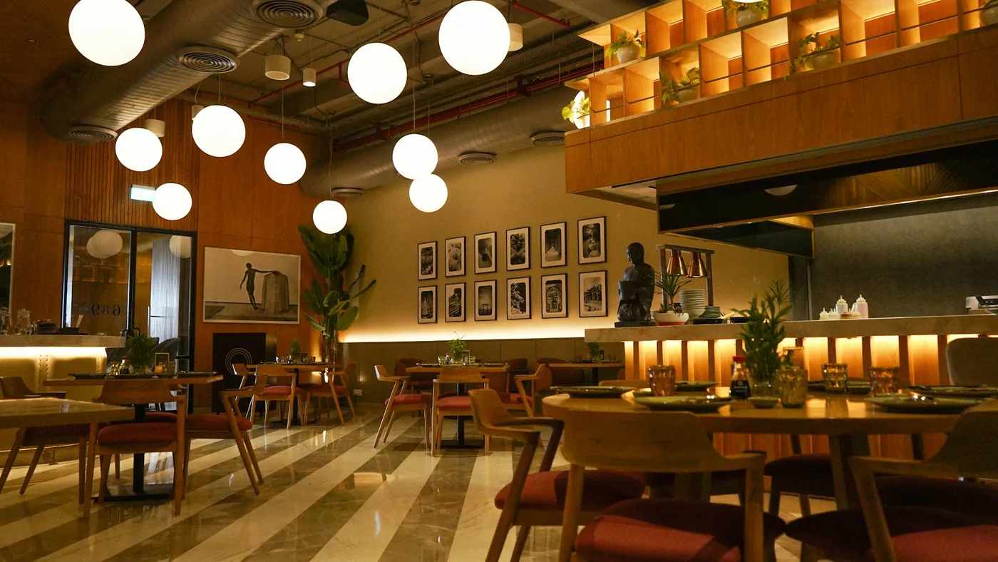A restaurant dining room with upholstered seating and window treatments