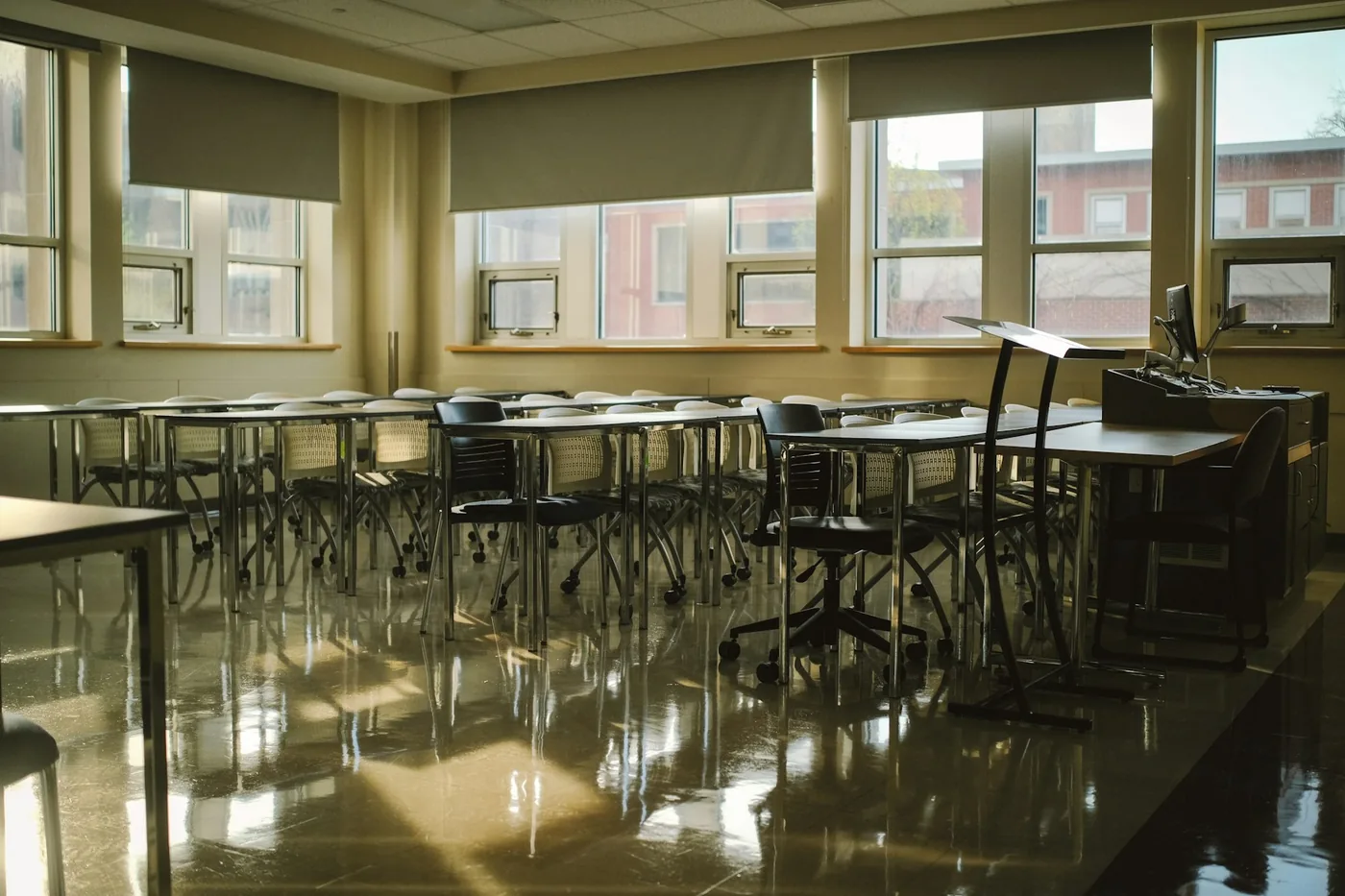 A bright school classroom with blinds on a row of windows